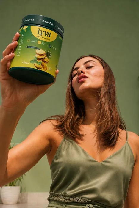 Mulher segurando o pote de lyva ao sol