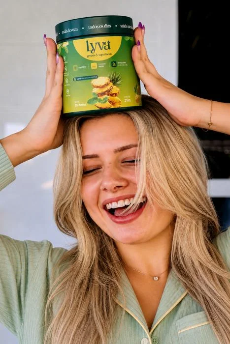 Mulher sorrindo com o pote de lyva